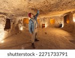 Tourist man in Kaymakli underground city ancient cave in Cappadocia, Turkey.