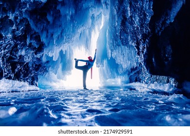 Tourist Man In Mysterious Blue Ice Cave Or Grotto On Frozen Lake Baikal. Concept Adventure Surreal Winter Landscape With People.