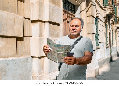 Tourist Man On The Street Looking Map Wondering Where He Should Go. Urban Traveling Leisure. Travel Guide, Tourism In Europe.