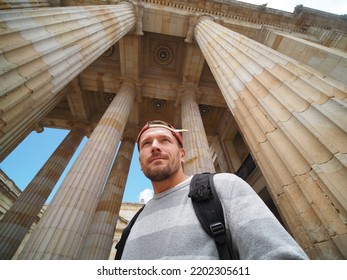 Tourist man standing in the middle of big columns in historical building.  - Shutterstock ID 2202305611