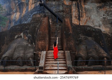 Tourist near the stone paws of the lion of the ancient stone fortress and palace of Sigiriya. Rock of the Lion - Powered by Shutterstock