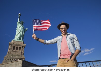 Tourist In New York Visiting The Statue Of Liberty With An American Flag 