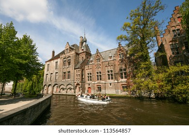 Tourist On Boat Trip In Bruges Canal, Belgium.