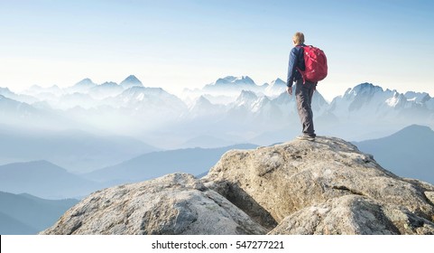 Tourist on the peak of high rocks. Sport and active life concept