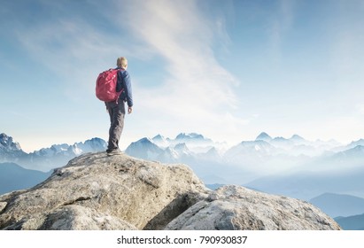 Tourist on the peak of high rocks. Sport and active life concept