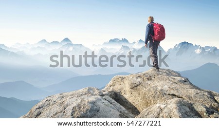Tourist on the peak of high rocks. Sport and active life concept

