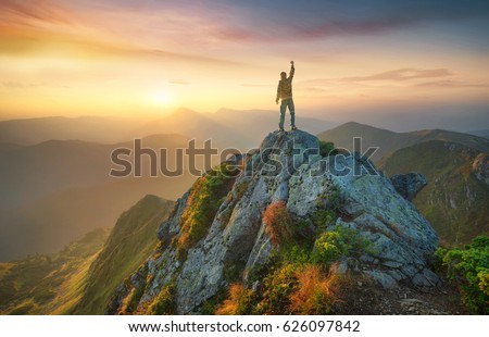 Tourist on the peak of high rocks. Sport and active life concept