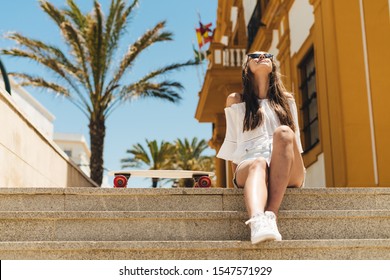 a tourist on the steps of the city, sitting, turning her face to the sun