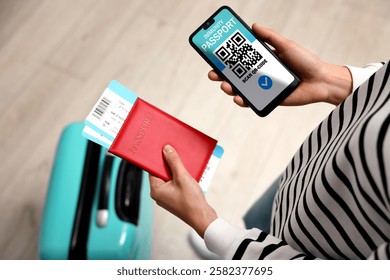 Turista con pasaporte, billetes de avión y teléfono móvil en el interior, vista superior. App de pasaporte de inmunidad con código QR en la pantalla del dispositivo