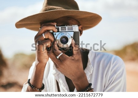 Tourist, photographer and black man with camera to take photograph or pictures during travel adventure in summer on nature vacation. Closeup of male on photography trip holiday outdoors in safari