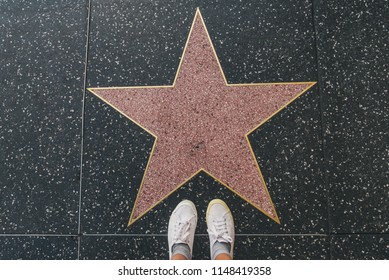 Tourist photographing her with an empty star on the Walk of Fame in Hollywood