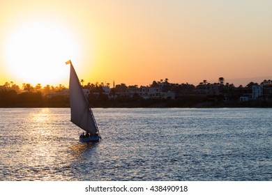 Tourist sailboat at Luxor waterfront during sunset.