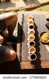 Tourist Sat To Taste Eight Different Kinds Of Indonesian Coffee At A Touristic Coffee Plantation, Bali, Indonesia