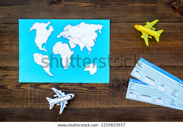 tourist set with toys and tickets for traveling
with kids wooden background top
view