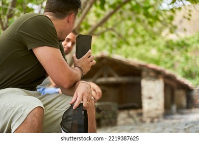 Tourist Showing Smartphone To Young Male In Ancient Patones De Arriba Slate Stone Washing Place