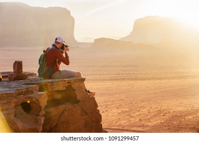 Tourist sits on edge of rock in Wadi Ram desert. Jordan sunset landscape - Powered by Shutterstock