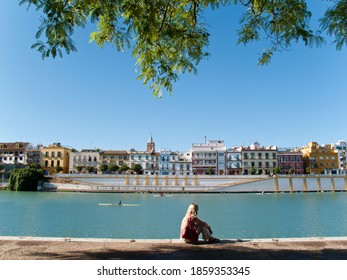 Tourist Sitting On Waterfront In Seville, Spain