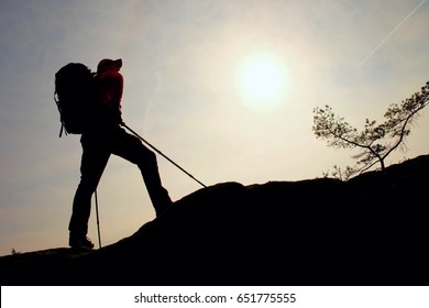 Tourist With Sporty Backpack And Poles In Hands Stand On Rock  Watching Up To Hill For Next Step. Sunny Spring Daybreak In Mountains. Vivid And Strong Vignetting Effect.. 