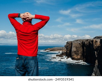 Tourist standing and enjoy view of stunning mini cliff in county Clare, Ireland. Travel and tourism. Bald man in red shirt, slim athletic body type in nature setting. - Powered by Shutterstock