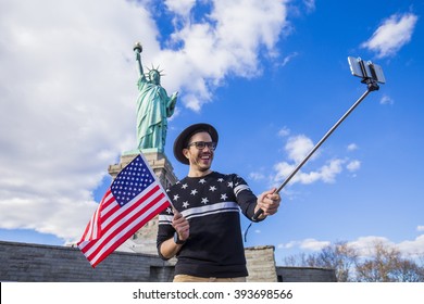 Tourist Standing Under The Statue Of Liberty In New York With A Selfie Stick