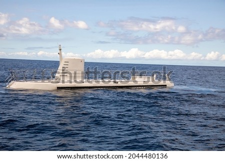 Tourist submarine above water line in Caribbean Sea on sunny day.