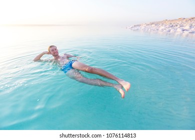 Tourist swims in turquoise water of the Dead Sea. Jordan landscape
