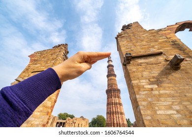 Tourist Takes A Forced Perspective Photo Of Her Hand Touching The Qutub Minar Column In New Delhi India