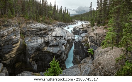 A tourist takes a photo of Mistaya Canyon in Banff National Park, Mistaya River, Alberta, Canada