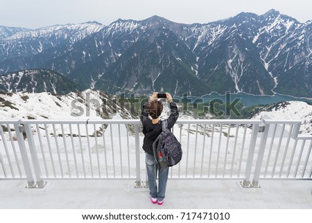 Tourist taking photo on viewing platform of Tateyama Kurobe Alpine Route in Japan