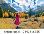 Tourist taking photo of Siguniangshan in autumn, Sichuan in China.