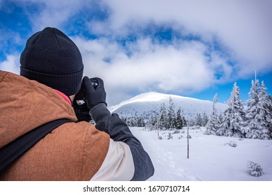 Tourist is taking photos of Snezka in Krkonose. Man is photographing Snezka. Winter trail - tourist on the trail, Karkonosze, krkonose, Mount Snezka