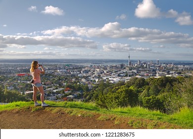 Tourist taking photos of the view of Auckland, New Zealand