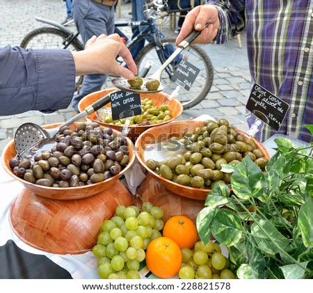Tourist tastes artisan olives on village market