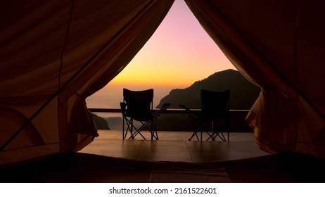 Tourist tent in camp among with mountain view on sunrise. View from tent camping on amazing sunrise with mountains and two folding camping chair. Travel vacation on nature - Powered by Shutterstock