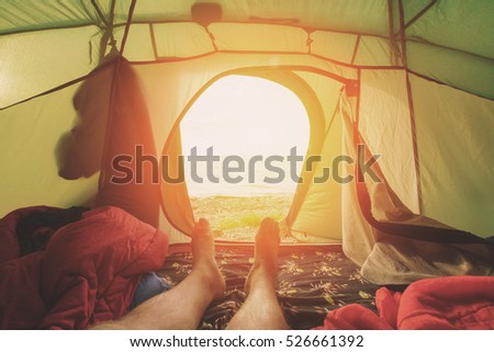 Tourist tent inside with men's feet, sunny