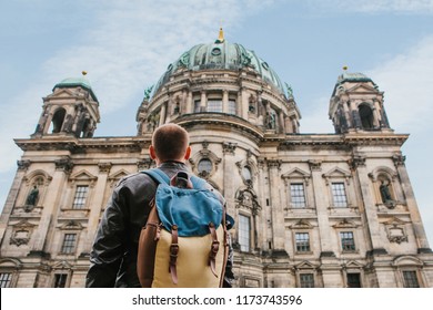 A tourist or traveler with a backpack looks at a tourist attraction in Berlin called Berliner Dom. Traveling in Germany.