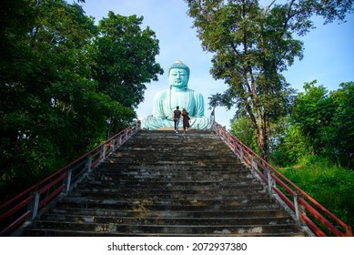 tourist is traveling and sightseeing at The Great Buddha (Daibutsu) bronze statue of the Wat Doi Phra Chan-in Buddhist temple in the city of Mae Tha in Lampang Prefecture, Thailand.