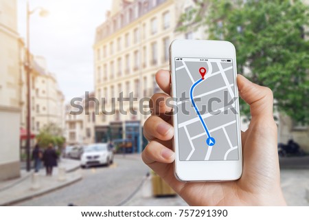 Tourist using GPS map navigation app on smartphone screen to get direction to destination address in the city streets, travel and technology