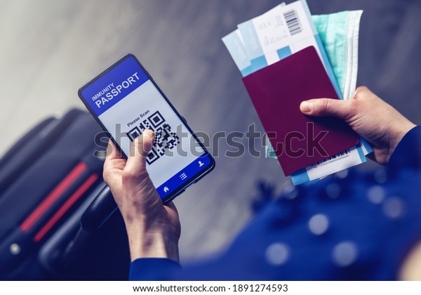 tourist using immunity passport app in mobile\
phone for travel