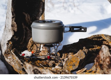 Tourist utensils, a pan stands on a burner, cooking on a camp burner, cooking in camping conditions in winter. High quality photo