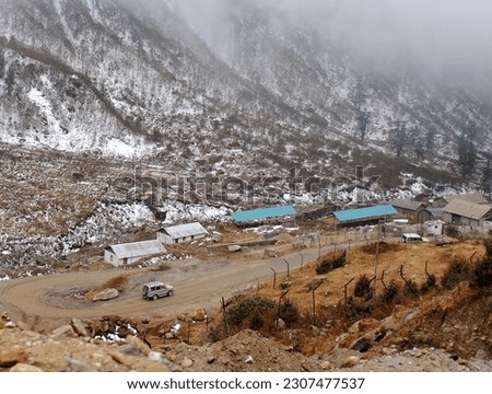 Tourist vehicles negotiating fog and snow plying on the zig-zag rough road after the fresh snowfall at JN Marg in Kyongnosla in Sikkim. From 500 to 1000 tourist vehicles ply daily during season time. Stockfoto © 