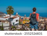 A tourist in the Victoria Garden looks at the town of La Orotava