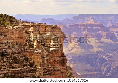Tourist viewpoint and rockwalls of the South rim of the Grand Canyon with beautiful long sight view in the background.