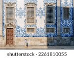 Tourist walking, azulejos tiles over Chapel Of Souls, Porto, Portugal