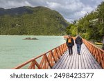 Tourist walking in Caleta Tortel village in the south of Chile, Aysen Region. This coastal village is located between the mouth of the Baker River and a small embayment of the Baker.
