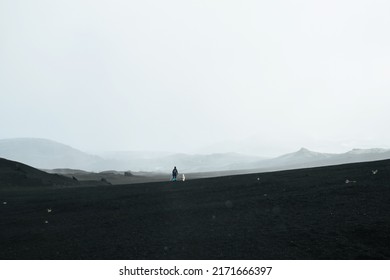 Tourist Walking With Dog To Climb The Top Of Volcano Mountain, Hills Of Slag Lava Field