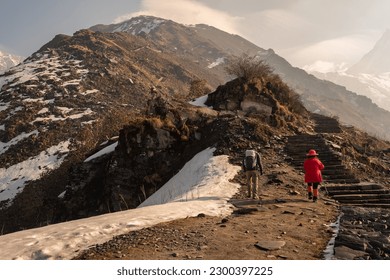 Tourist walking on steep rock stairs to Upper view point (4,200 m) of Mardi Himal trekking route in Annapurna region of Nepal.