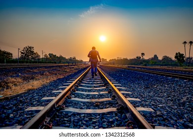 Tourist Walking And Running On Railway Train On Morning For Journey On Summer Season Holiday, Blue And Orange Sky On Sunrise, Tourist Holding Backpack Motion On Track Way, Inspiration Travel Of Life