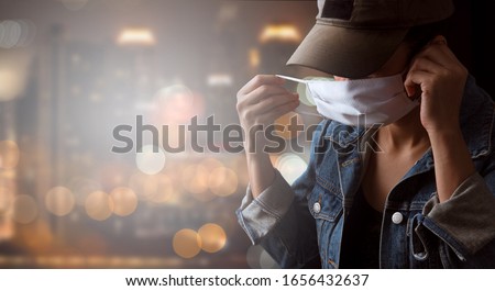 A tourist wearing a mask isolated on city background. Promoting people use face mask to protect themselves from virus infection in Corona virus crisis 2020