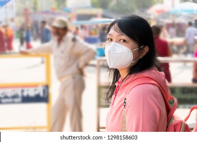 A tourist wearing mouth mask against air smog pollution at Mahabodhi Temple Complex in Bodh Gaya, India 